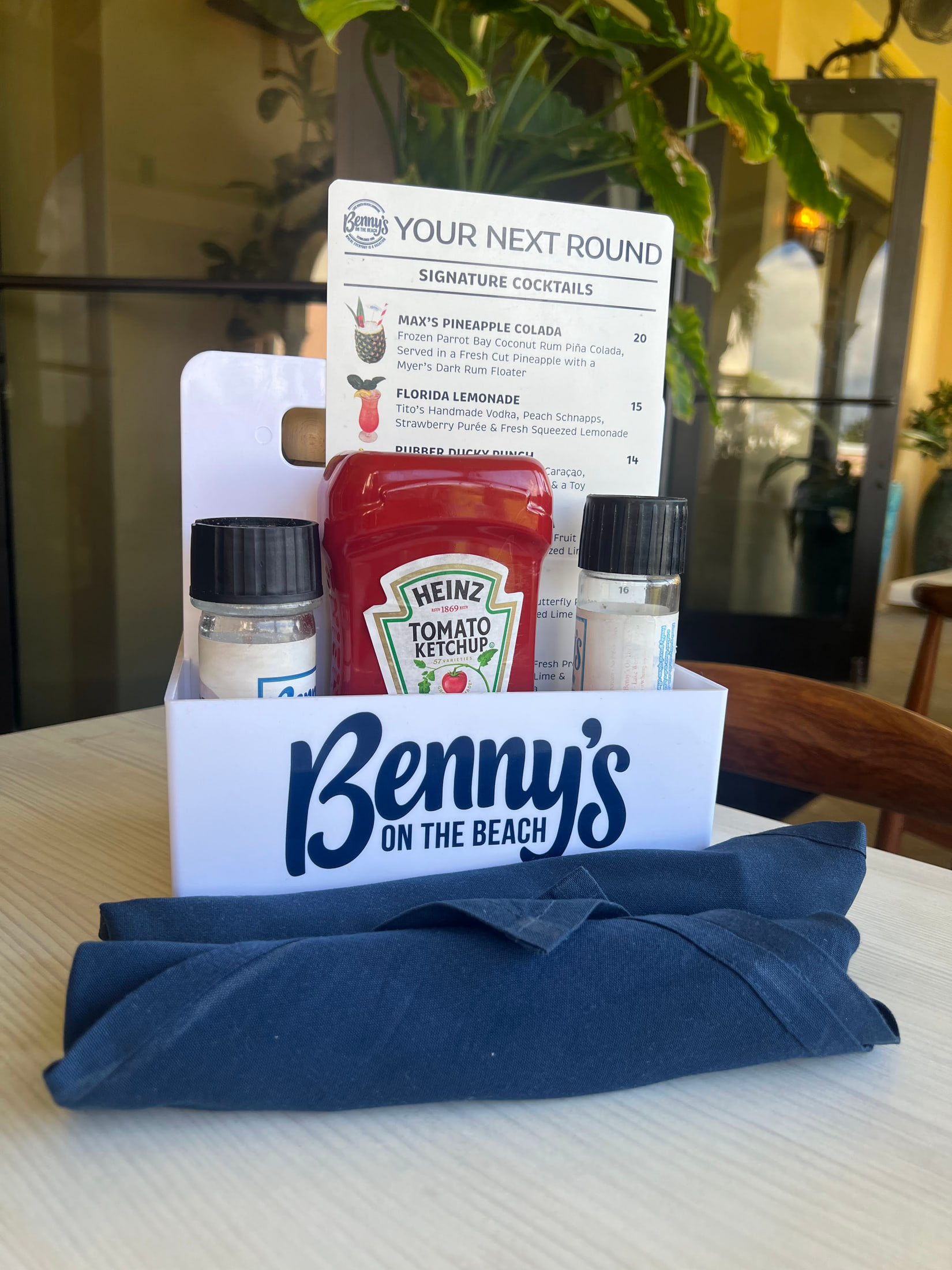 Printed cocktail menu cards and a branded table caddy for Benny's on the Beach